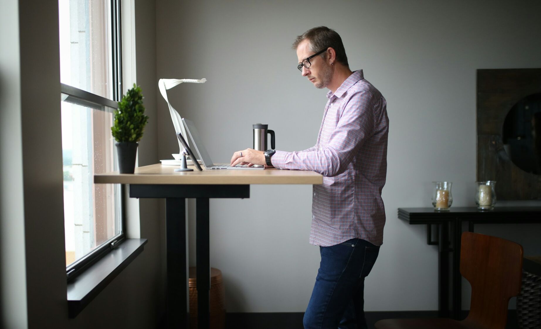 Man uses a standing desk in his workspace
